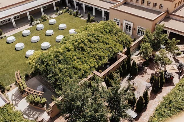 Aerial view of an outdoor wedding reception set up on the courtyard lawn at Hotel Albuquerque at Old Town