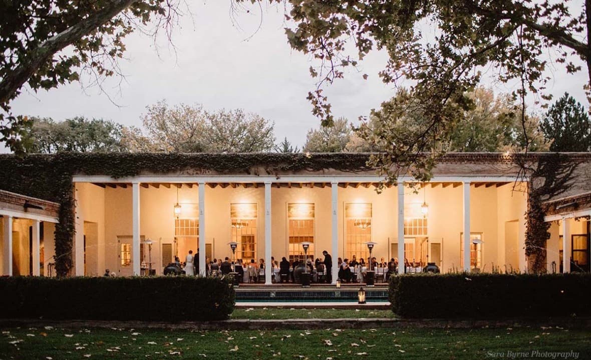 Wedding reception under the lit covered portal at Los Poblanos Historic Inn in Los Ranchos, New Mexico